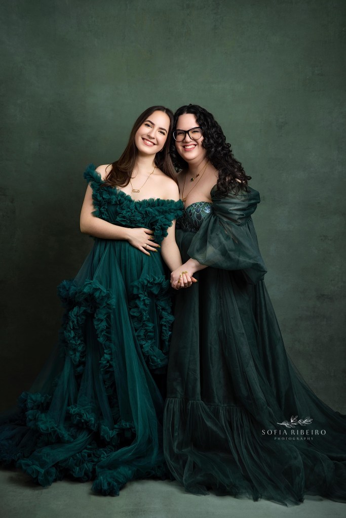 a portrait of two sisters in matching green gowns taking during a sweet 16 photo session in NJ