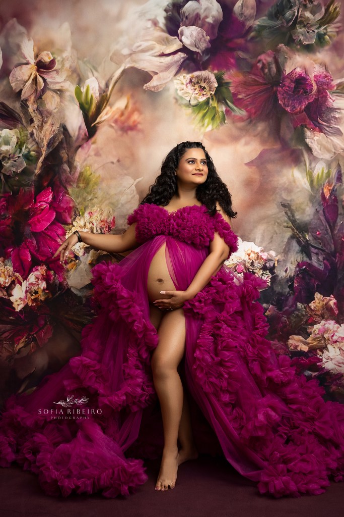 expectant mom to be in a pink ruffled tulle gown