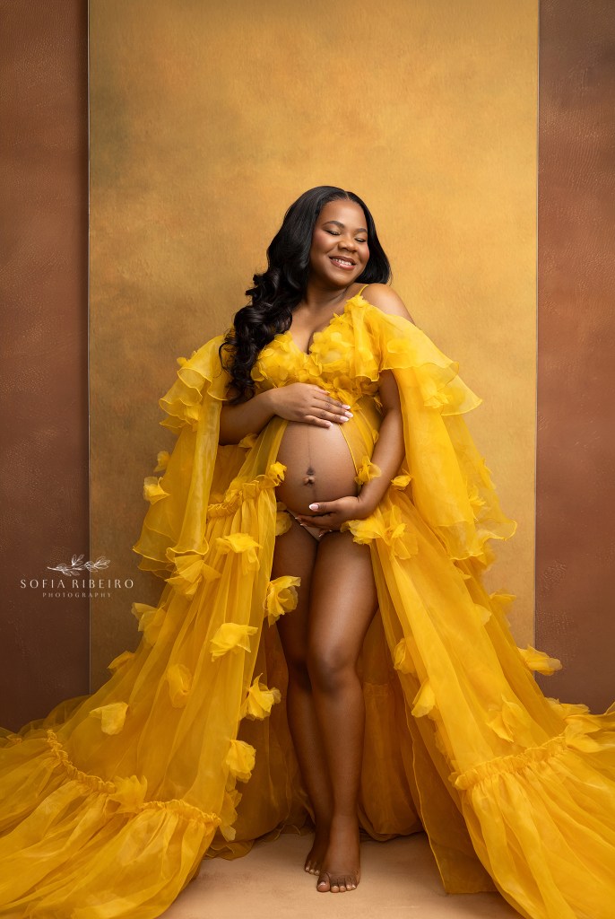 mom glows in yellow with her baby bump exposed for maternity portraits