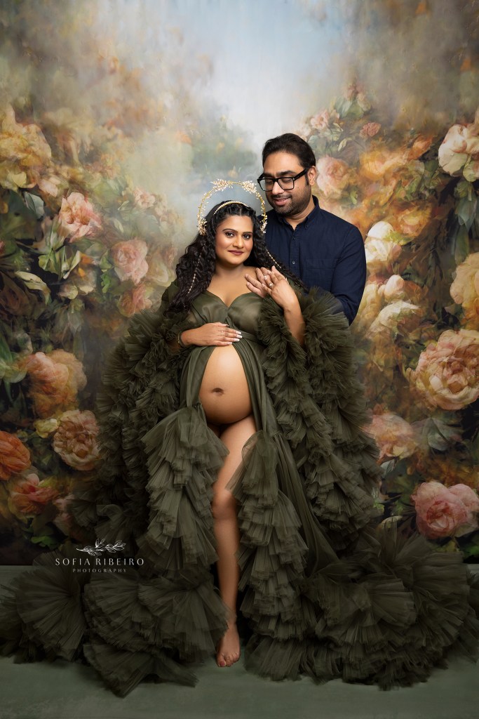 mom and dad pose together in shades of green and navy