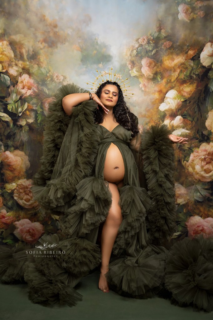 nj maternity photographer captures mom to be in a radiant green gown against ethereal backdrop with golden halos