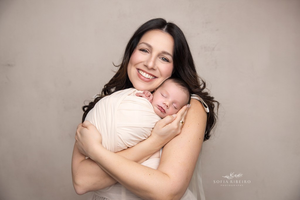 mom snuggles her son with a smile on her face
