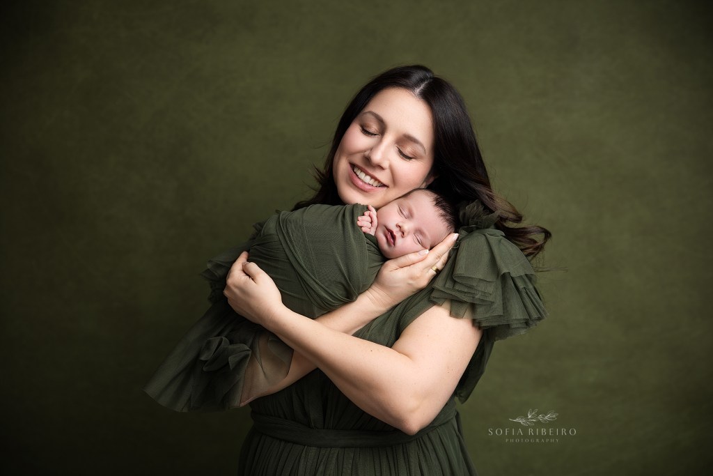 mom snuggles her son with a smile on her face