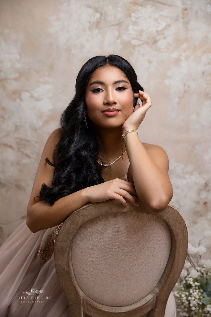 a closeup of a teenager posed against a chair