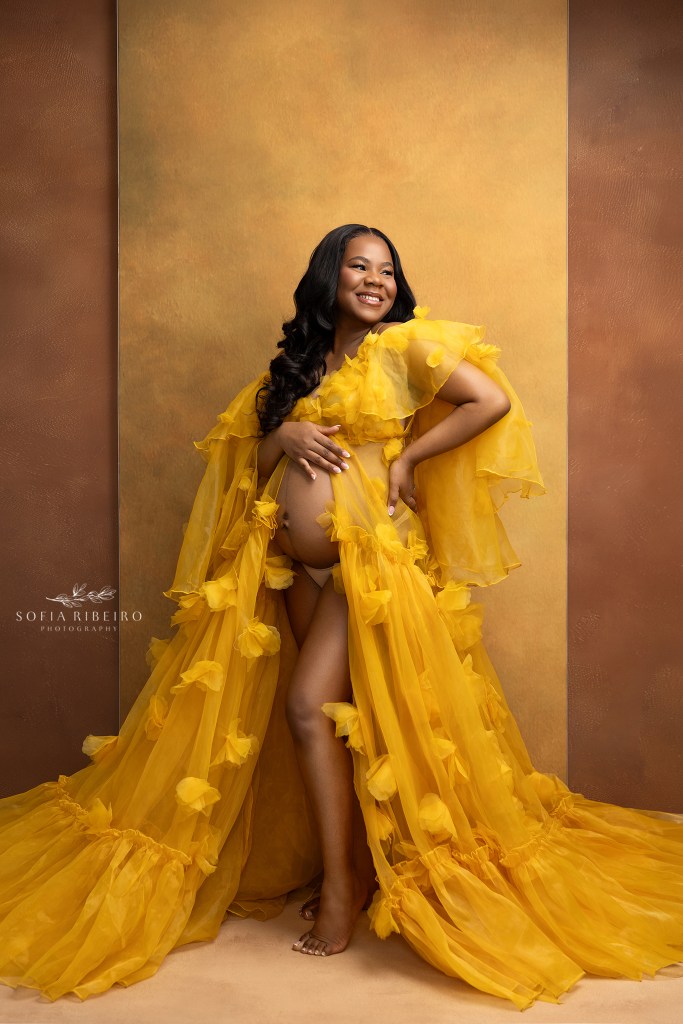 gold and blue tones portray an elegant maternity session for mom and dad and soon to arrive baby. ruffled, gold and blue gowns highlight mom's baby bump