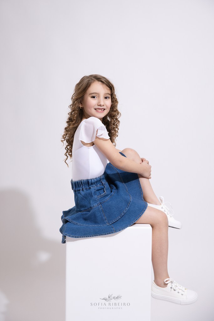 children's headshot photographer captures personality portrait in denim looks against a white backdrop for a little girl