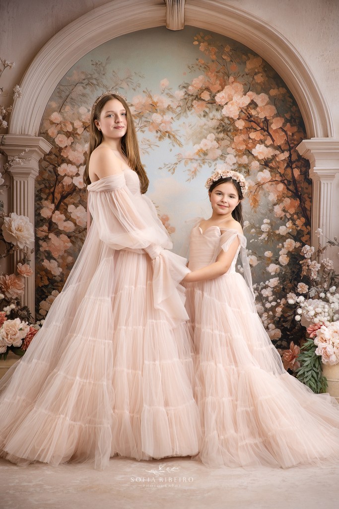 bridgerton inspired sister photos against a floral arch backdrop