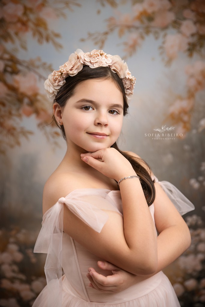 a fine art portrait of a young girl in pink against a baroque floral backdrop