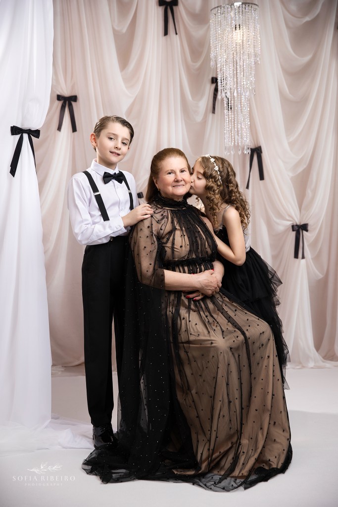 granddaughter palces a kiss on grandmother's cheek for a session with her grandchildren with sofia ribeiro photography