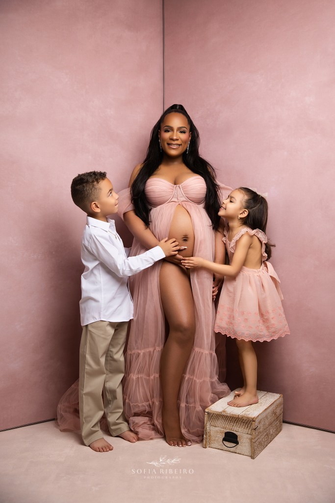 mom smiles with her two older children together for a portrait