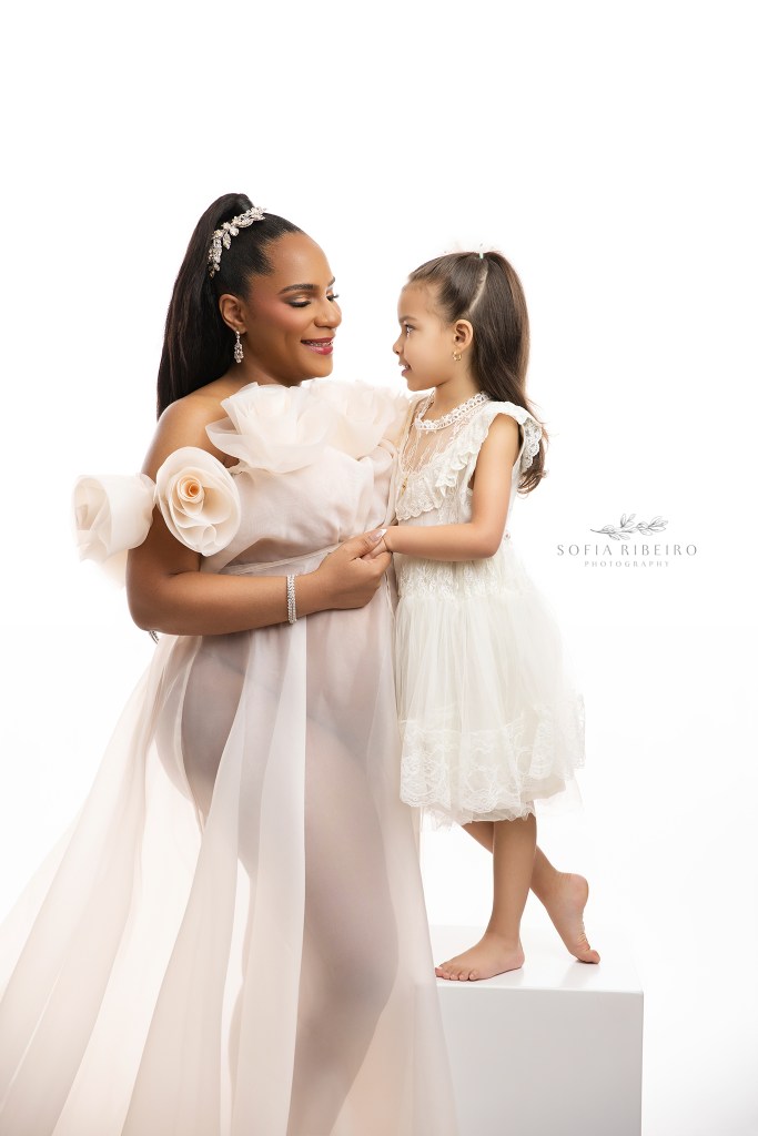 nj maternity photographer captures a mom and daughter together in cream looks against a backlit white backdrop