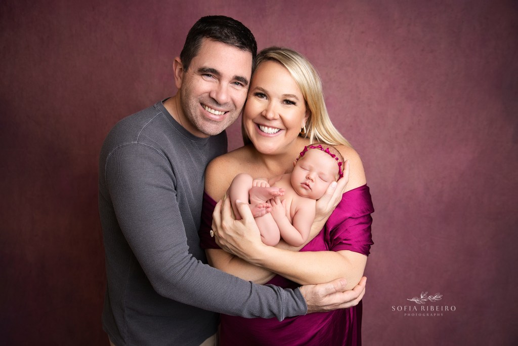 newborn baby girl nestlecd in parents album in nj newborn photography studio in shades of pink