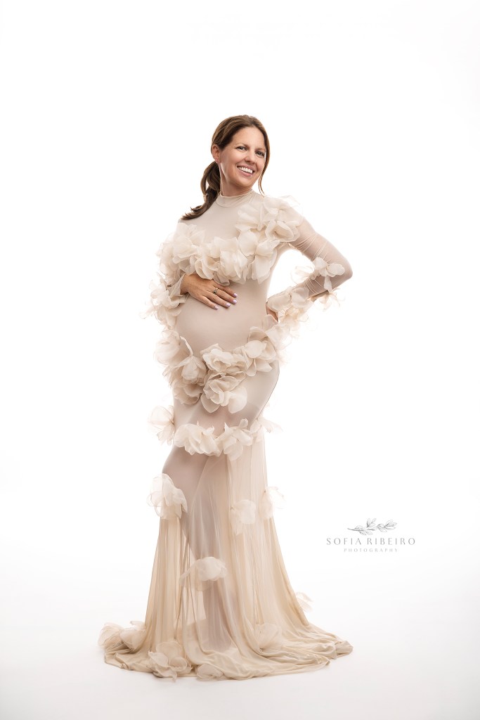 a sheer mesh tulle floral gown highlights mom to be's baby bump during maternity portraits in studio in nj