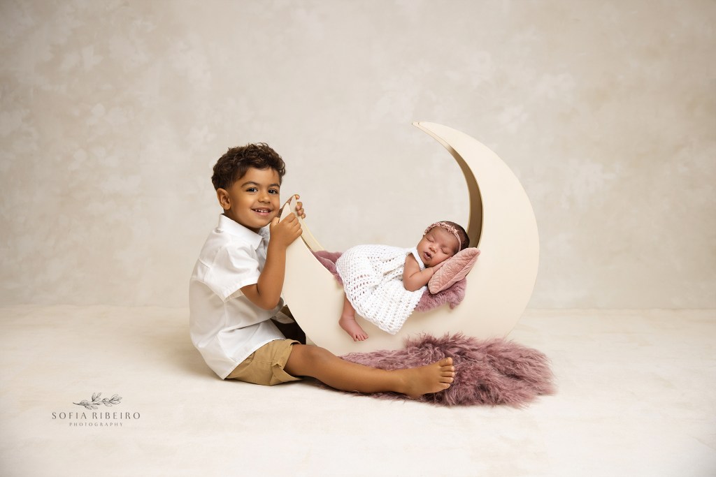 nj newborn photographer specialized in family newborn posing, big brther poses with sister on moon prop