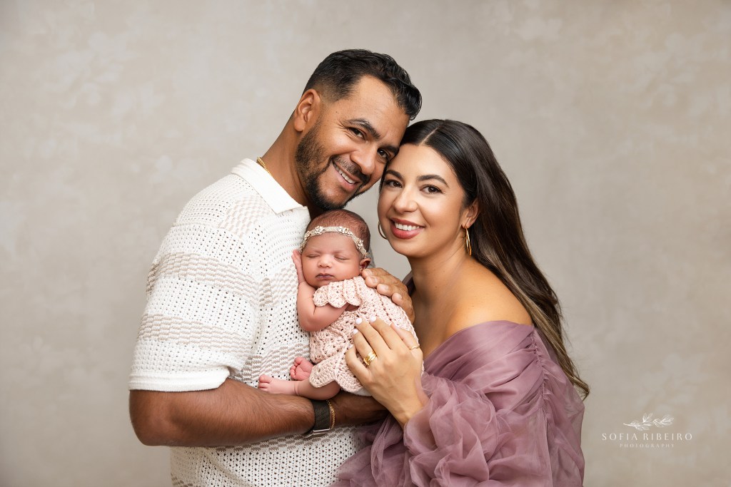 mom and dad share a loving portrait together with their baby daughter