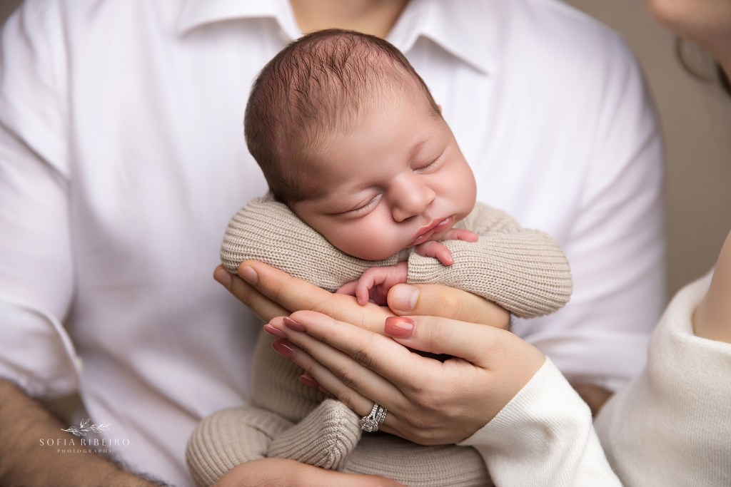 a closeup of baby in parents hands