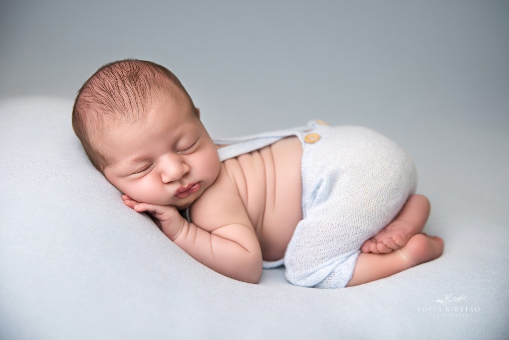 a squishy baby posed against a blue backdrop