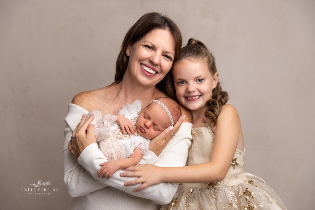 mom snuggles her daughters during an nj newborn photography session
