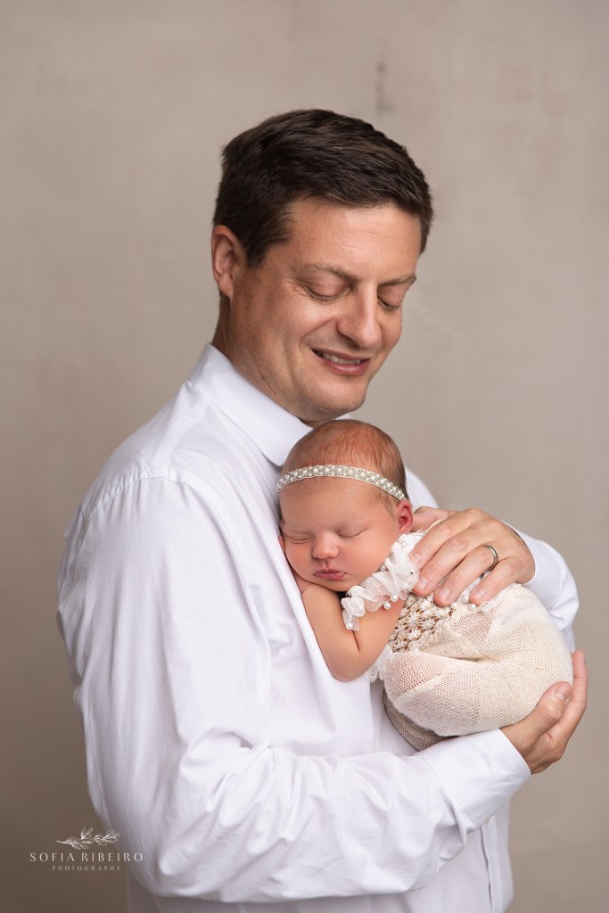dad cradles his baby girl during a newborn photography session in nj