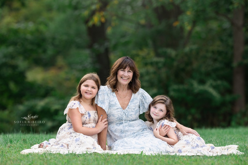 a grandmother posed with granddaughters during a family photo session in nj